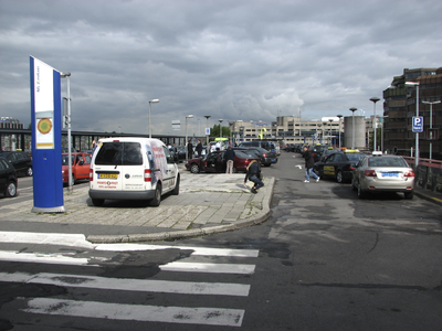 905473 Gezicht over het Stationsplateau boven het Stationsplein te Utrecht, met geparkeerde auto's en taxi's.